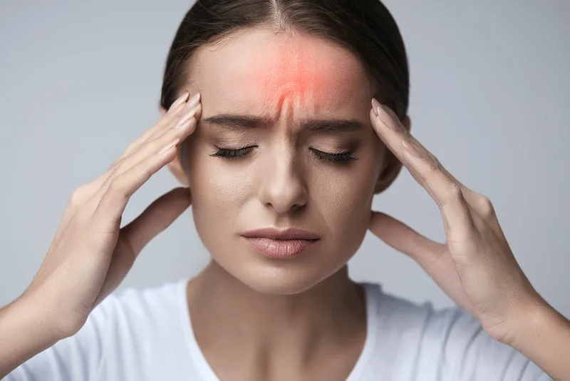 Woman pressing her temples with a headache
